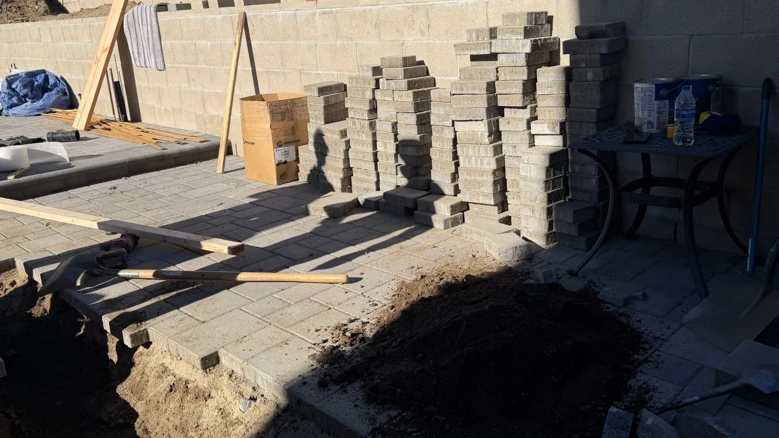 New sewer line installation with preserved pavers staged for reinstallation at Burbank home