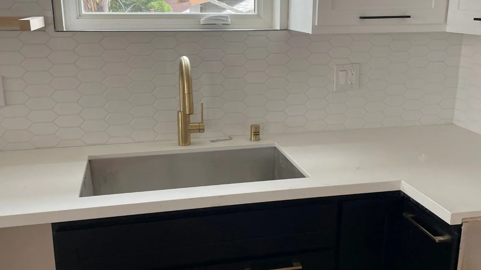 Modern kitchen sink and brass faucet installation in La Cañada