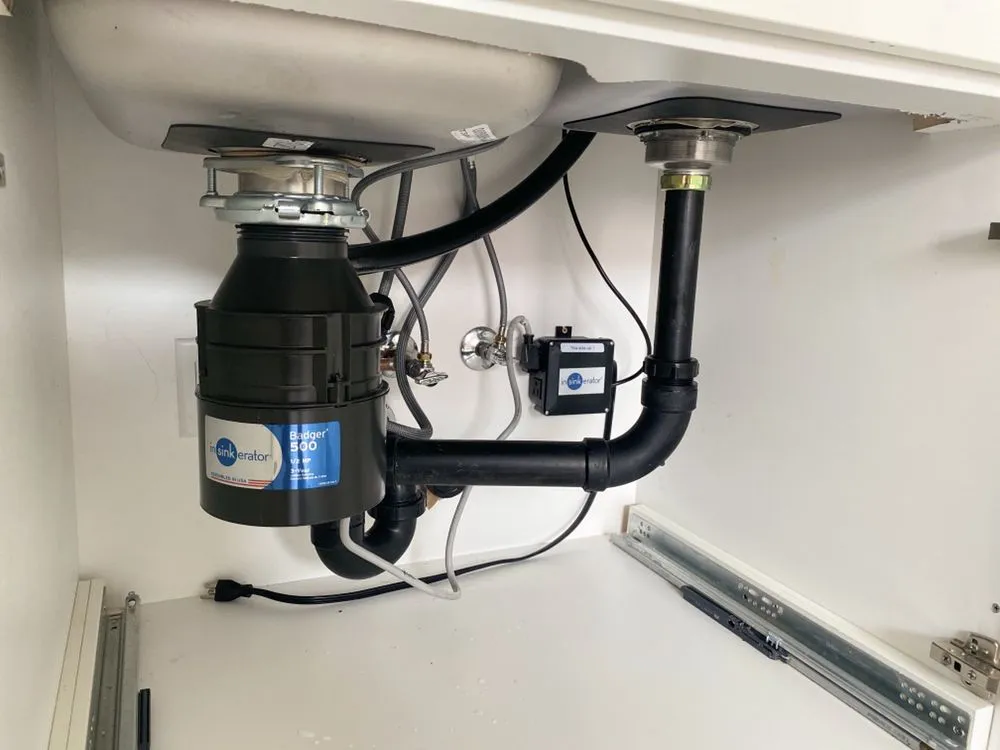 La Cañada new garbage disposal installation with properly configured drain piping under kitchen sink