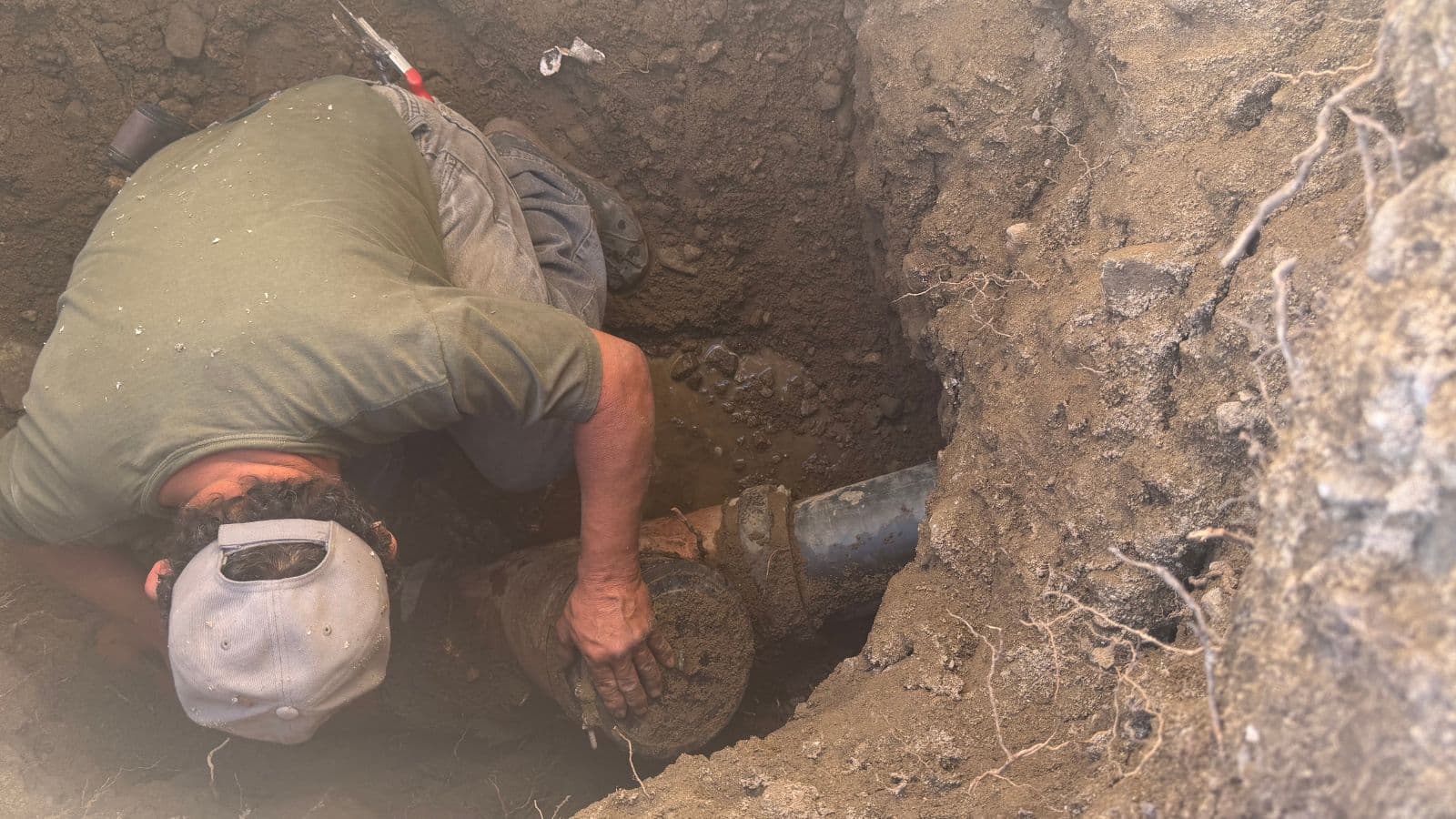 Tujunga sewer line before repair – street excavation exposing damaged clay pipe with root intrusion