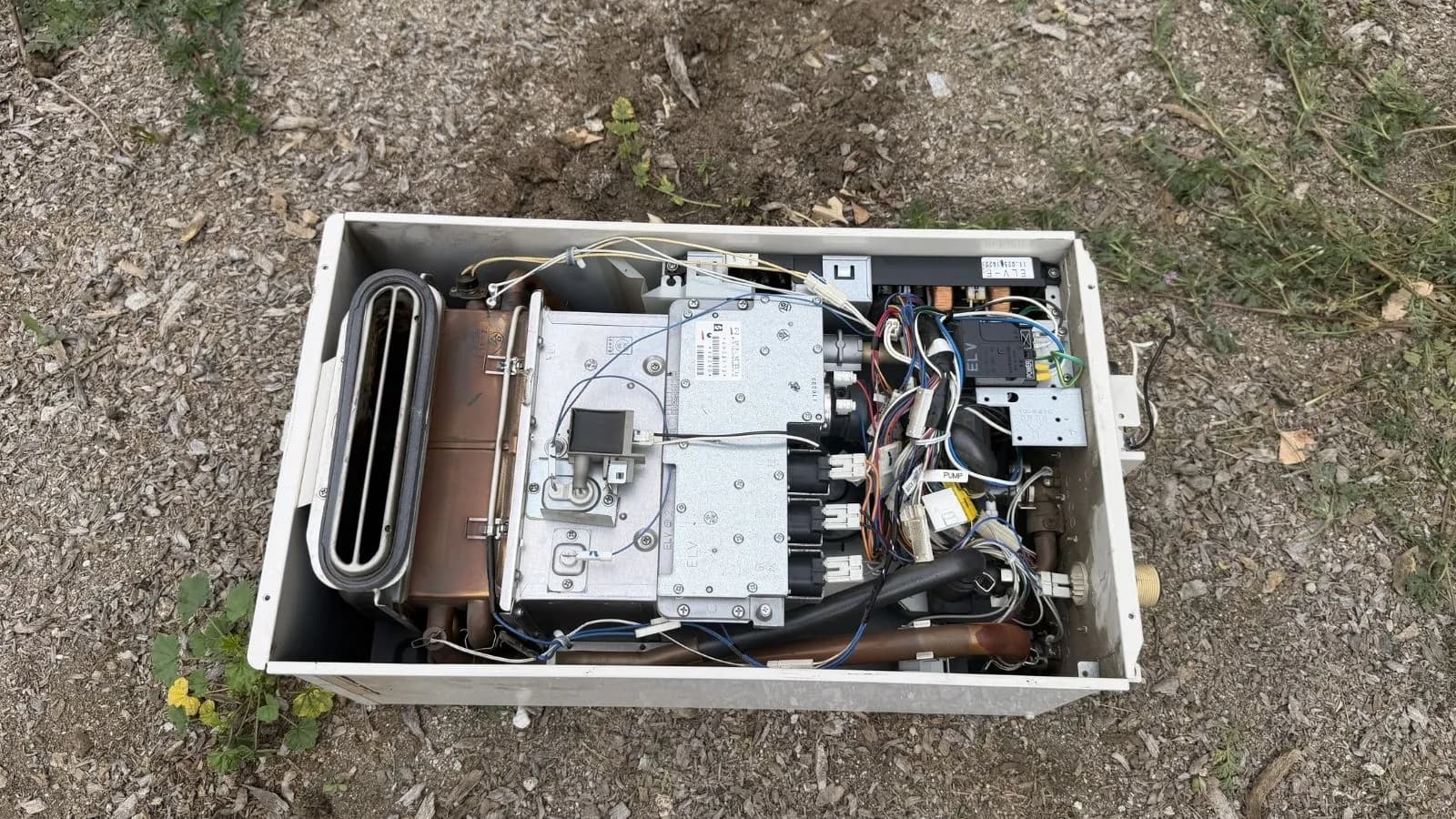 Broken outdoor tankless water heater opened for inspection in Tujunga, CA